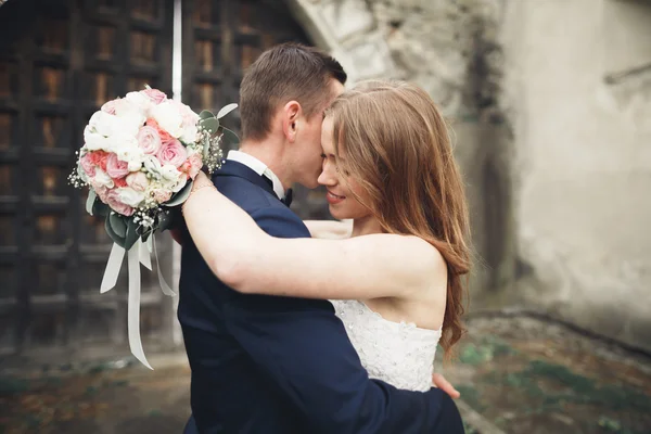 Beautiful romantic wedding couple of newlyweds hugging near old castle — Stock Photo, Image