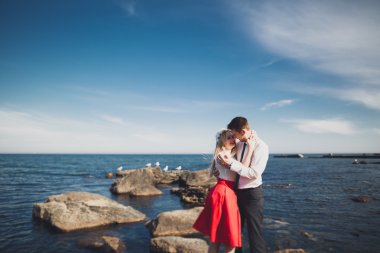 Deniz, mavi gökyüzü yakınındaki taş poz romantik sevgi dolu Çift