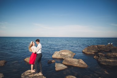 Deniz, mavi gökyüzü yakınındaki taş poz romantik sevgi dolu Çift