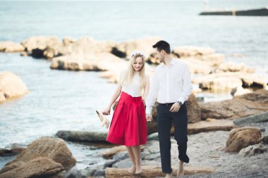 Deniz, mavi gökyüzü yakınındaki taş poz romantik sevgi dolu Çift