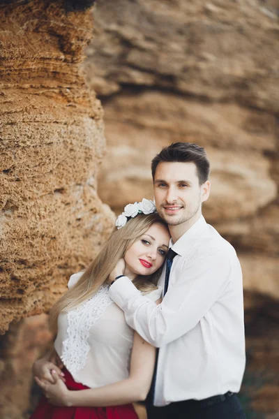 Casal amoroso romântico andando na praia com pedras e pedras — Fotografia de Stock