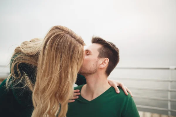Υπέροχο ζευγάρι φιλί και αγκαλιάζει από ένα dock στη θάλασσα — Φωτογραφία Αρχείου