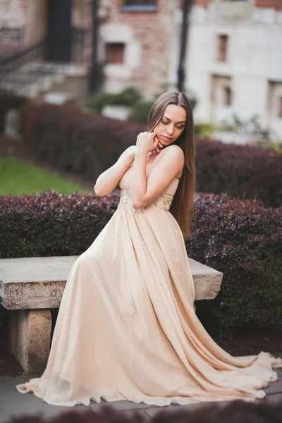 Bella donna felice nel parco una calda giornata di primavera seduta sulla panchina — Foto Stock