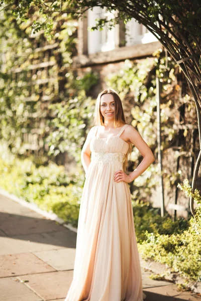 Atractiva joven con vestido largo disfrutando de su tiempo al aire libre en el fondo del atardecer del parque —  Fotos de Stock