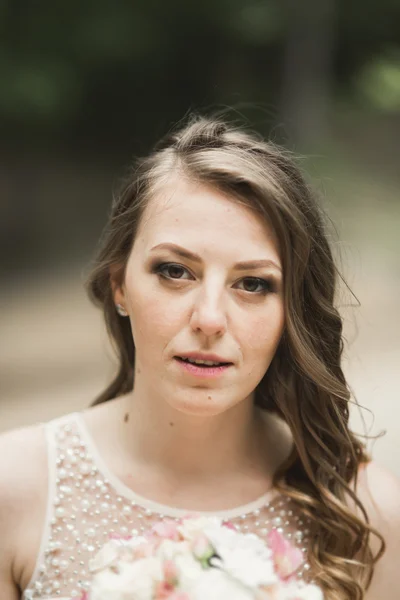 Splendida sposa in abito elegante bouquet tenuta in posa vicino foresta e lago — Foto Stock