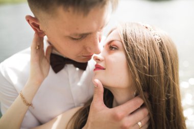 Bahar mevsiminde öpüşen düğün çifti. Yakın plan portre.