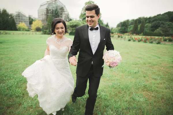 手を取りながら新婚夫婦が走って公園に飛び込む — ストック写真