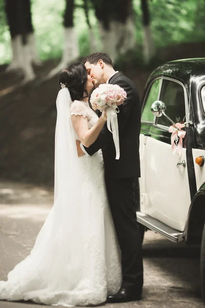 Bella coppia di nozze posa vicino splendida auto retrò — Foto Stock