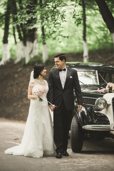 Bella coppia di nozze posa vicino splendida auto retrò — Foto Stock