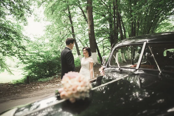 아름 다운 웨딩 커플 화려한 복고풍 자동차 근처 포즈 — 스톡 사진