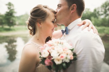 Gelin ve damat güzel düğün buket tutarak. Göl, orman