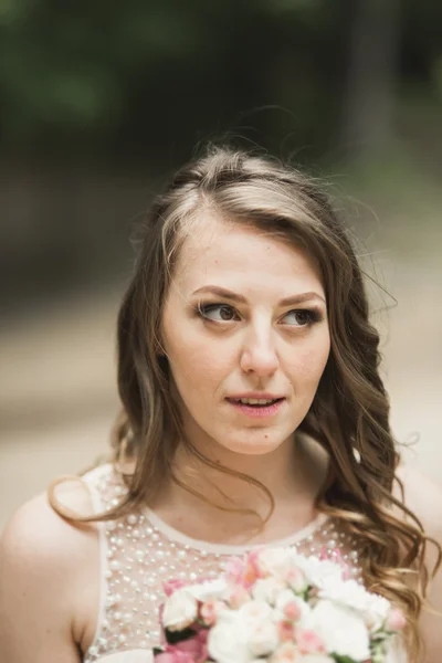 Splendida sposa in abito elegante bouquet tenuta in posa vicino foresta e lago — Foto Stock