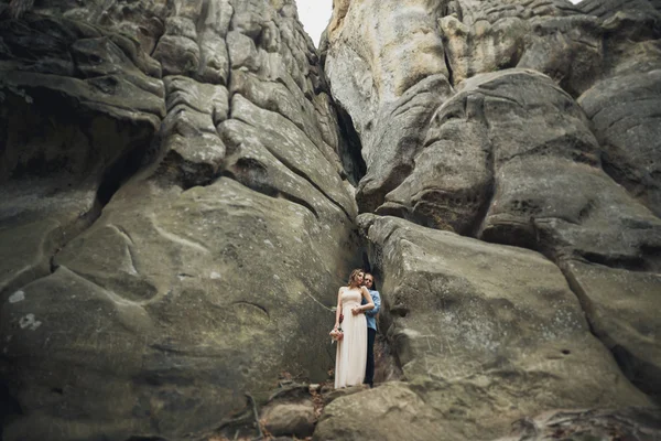 Feliz boda pareja besándose y abrazándose cerca de un alto acantilado —  Fotos de Stock