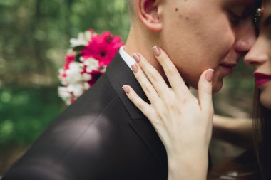 Genç ve güzel bir çift parkta öpüşüyor ve gülümsüyor.