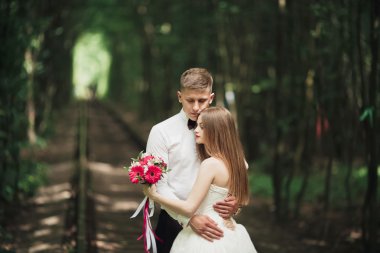 Genç düğün çift, gelin ve damat bir demiryolundan poz