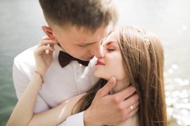 Bahar mevsiminde öpüşen düğün çifti. Yakın plan portre.