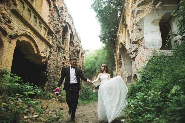 Beau couple de mariage romantique de jeunes mariés étreignant près du vieux château — Photo