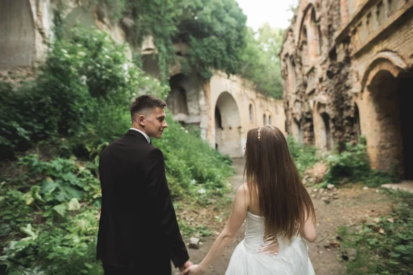 Glückliches Brautpaar in der Nähe des alten Schlosses auf dem Spaziergang — Stockfoto