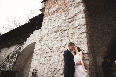 Muhteşem düğün çift, Gelin, damat öpüşme ve duvara yakın sarılma