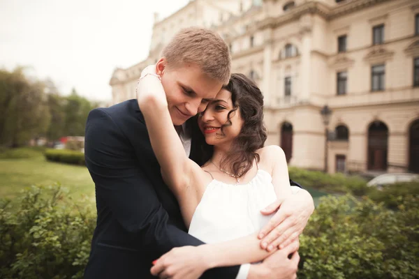 Casal de casamento bonito, noiva, noivo beijando e abraçando contra o fundo do teatro — Fotografia de Stock