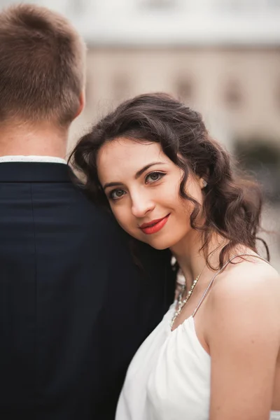 Mooie bruid leunde op achterkant van de bruidegom — Stockfoto