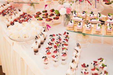 Çeşitli lezzetli tatlılar, yemek fikirleri ve kutlamalarla dolu bir büfe.