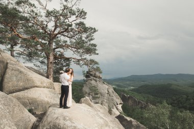 Muhteşem gelin, damat öpüşme ve sarılma Gösterim çarpıcı uçurum yakın: