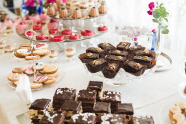 Çeşitli lezzetli tatlılar, yemek fikirleri ve kutlamalarla dolu bir büfe.