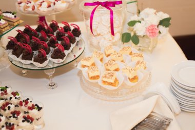 Çeşitli lezzetli tatlılar, yemek fikirleri ve kutlamalarla dolu bir büfe.