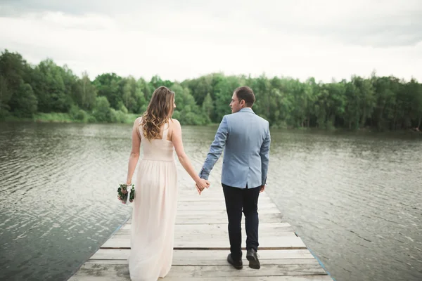 Novia y novio caminando por el río, sonriendo, besando —  Fotos de Stock