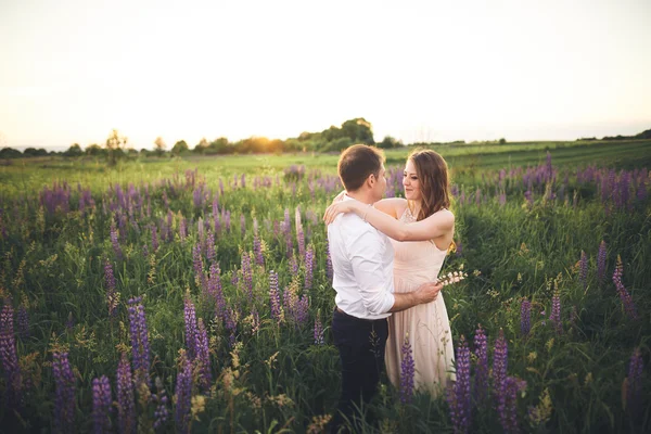 Érzelmi gyönyörű menyasszony átölelve newlywed vőlegény mögül egy mező Vértes naplementében — Stock Fotó