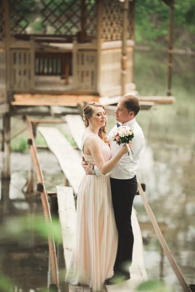 Pareja de boda abrazos y besos en el puente —  Fotos de Stock