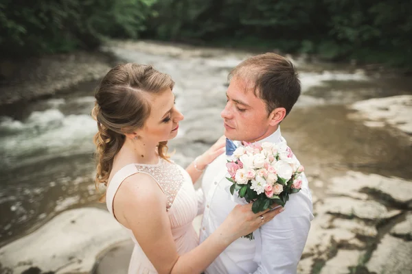 Novia y novio celebrando hermoso ramo de bodas. Lago, bosque —  Fotos de Stock