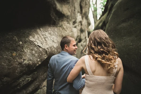 Splendido matrimonio coppia baci e abbracci nella foresta con grandi rocce — Foto Stock