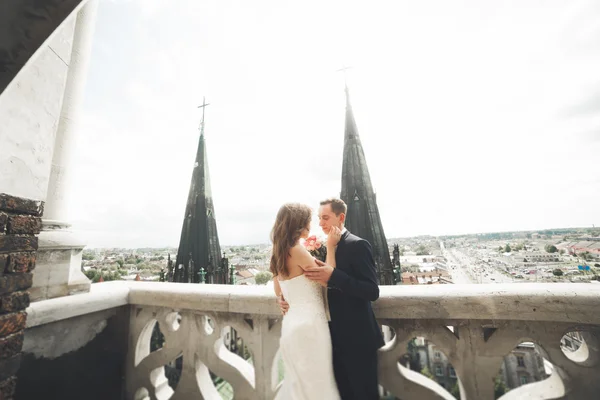 Stijlvol mooi bruidspaar zoenen en knuffelen op achtergrond panoramisch uitzicht op de oude stad — Stockfoto
