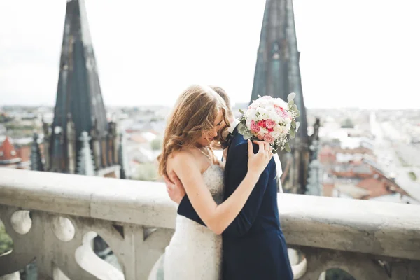 Stijlvol mooi bruidspaar zoenen en knuffelen op achtergrond panoramisch uitzicht op de oude stad — Stockfoto