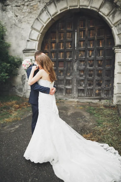 美丽浪漫的新婚夫妇在古堡附近拥抱 — 图库照片