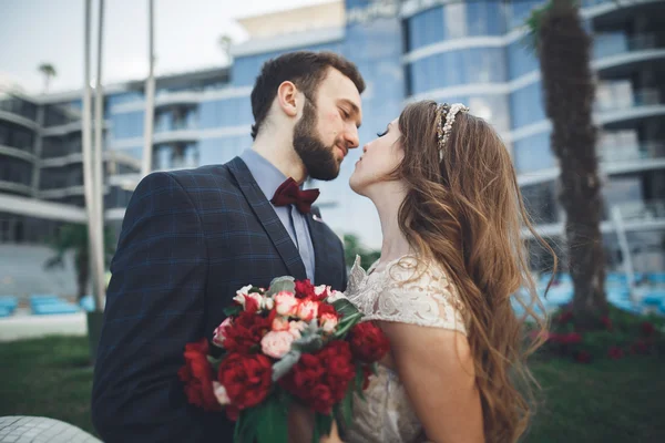 Élégant beau couple posant près du bâtiment en verre moderne — Photo