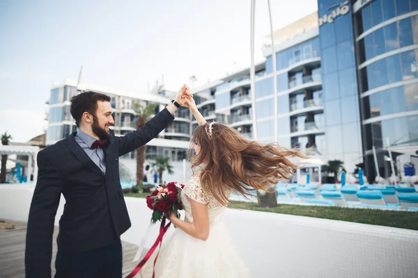 Elegante hermosa pareja posando cerca de edificio de vidrio moderno — Foto de Stock