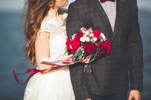 Casamento casal em pé em um cais sobre o mar — Fotografia de Stock