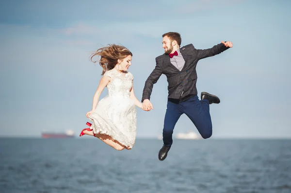 結婚式の幸せだけ結婚している若いカップルを祝う美しいビーチの夕日で楽しく、 — ストック写真