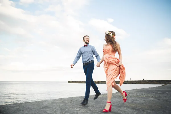 Mooie verliefde paar, trots met lange jurk wandelen op de pier — Stockfoto