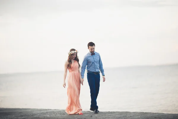 Casamento casal em pé em um cais sobre o mar — Fotografia de Stock