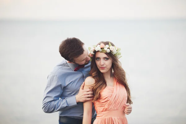 Casamento casal em pé em um cais sobre o mar — Fotografia de Stock