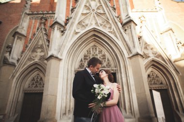 Yanında bir kilise poz zarif güzel düğün çifti. Krakow