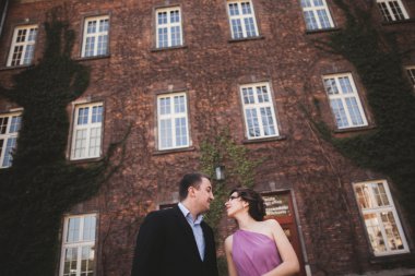 Genç düğün iki aşk hikayesi, gelin ve damat arka planda bina yakın poz sonra. Krakow