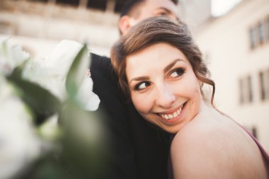 Mutlu düğün çift, damat, Gelin pembe elbise ile sarılma ve birbirlerine arka plan üzerinde gülümseyen duvarlar kalede