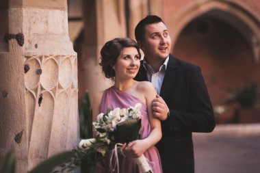 Genç çift aşk gelin ve damat ve arka plan üzerinde beyaz sütun içeren alan yakın poz. Krakow