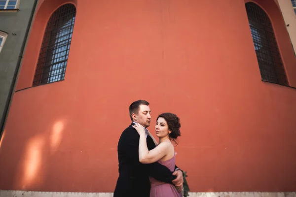 Gorgeous wedding couple, groom and bride with pink dress walking in the old city of Krakow — Stock Photo, Image