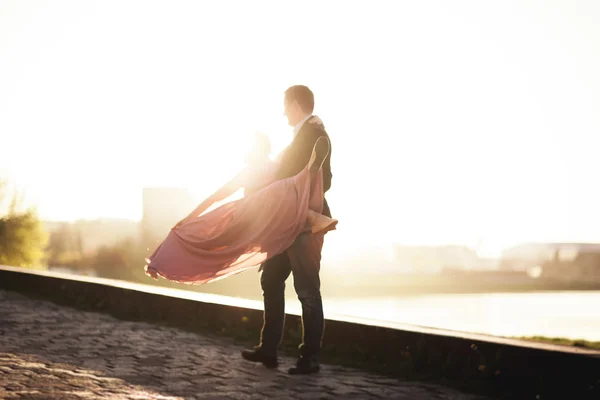 Casamento casal, noivo e vestido posando perto do rio com um copo ao pôr do sol — Fotografia de Stock